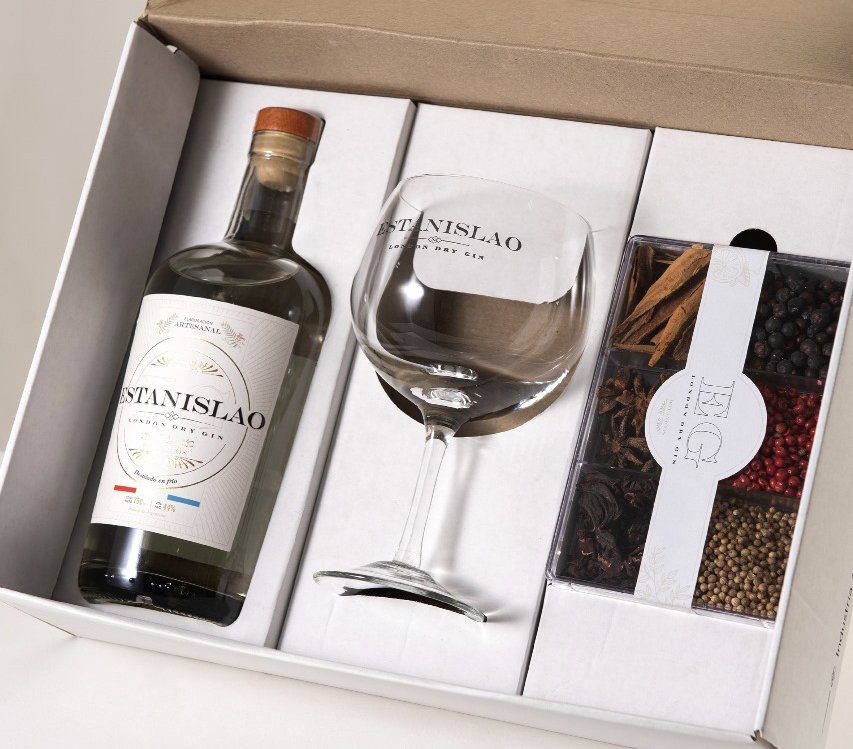 Packaging para gin Estanislao con botella, copa y botánicos en interiores a medida